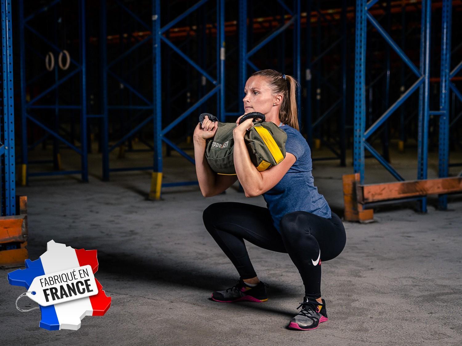 Femme en position squat complet avec sandbag S - LEVEL addict