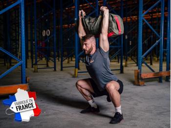 Homme en position overhead squat avec sandbag taille L - LEVEL addict