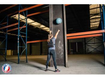 Femme portant gilet lesté noir de dos en exercice Wallball - LEVEL addict