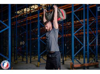 Homme en position overhead avec sandbag L - LEVEL addict