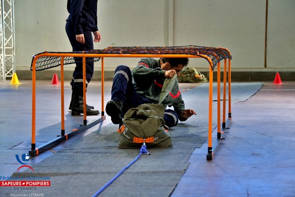 Pompier en train de tirer un sac de 40 kg sous un tunnel